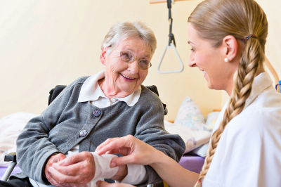 nurse putting bandage on senior woman's wounded hand