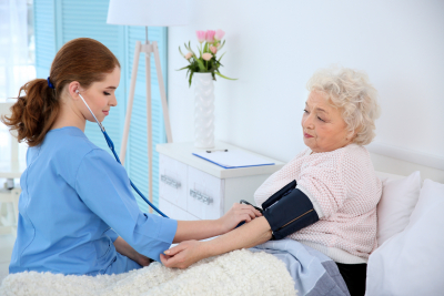 female nurse measuring senior woman's blood pressure