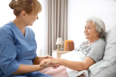 caregiver holding the hand of senior woman